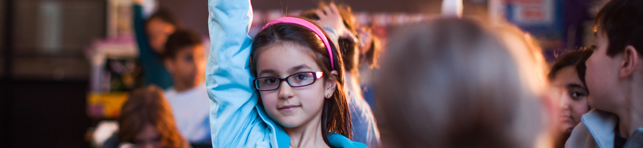 girl in classes raising hand 